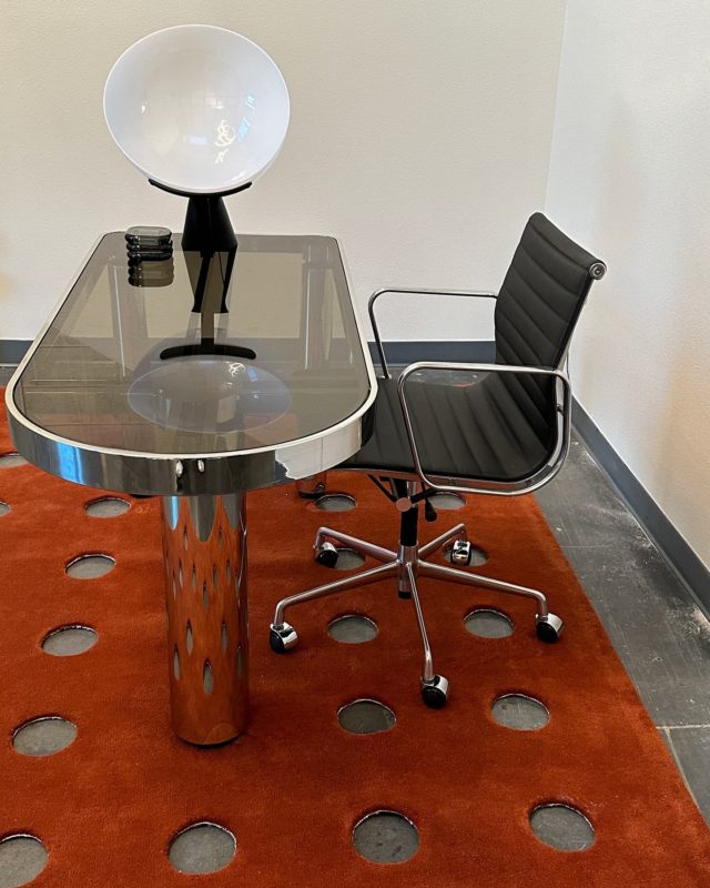 Entry desk area @chronicink Las Vegas by @vlc__studio featuring a 1970’s Karl Springer chrome writing desk, Angelo Mangiarotti Aida lamp, and a @bi_rite perforated rug 🧡